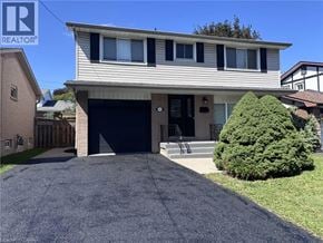 Hamilton apartment for rent - A house with a garage and a driveway in front.