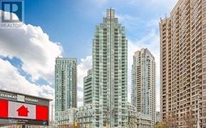 Mississauga (City Centre) condo for rent - A tall glass building stands in front of a smaller one.