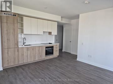 Vaughan (Vaughan Corporate Centre) condo for rent - A kitchen with wooden cabinets and a white backsplash.