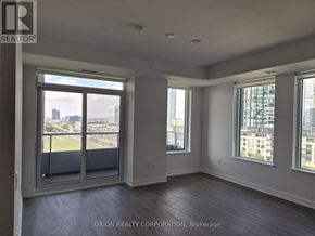 Vaughan (Vaughan Corporate Centre) condo for rent - A large empty room with a view of the city through the windows.