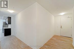 Toronto (Alderwood) condo for rent - A white room with a wooden floor and a door on the right side.