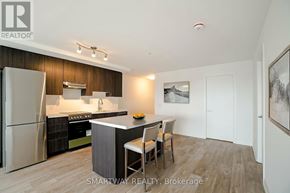 Toronto (Alderwood) condo for rent - A modern kitchen with a refrigerator, stove, and bar stools.