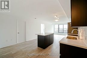 Toronto (Alderwood) condo for rent - A modern kitchen with dark wood cabinets and a white countertop.