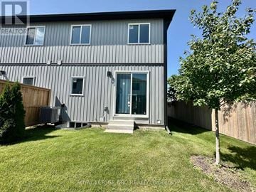 St. Catharines (Oakdale) townhouse for rent - A modern house with a grey exterior and a glass door.