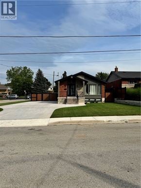 Stoney Creek apartment for rent - A house with a brown roof and a white fence is in the image.