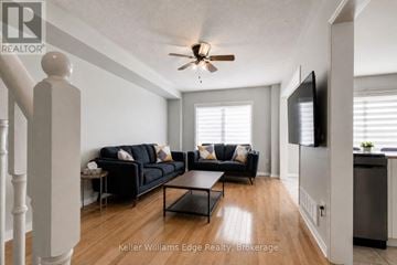 Burlington (Alton) townhouse for rent - A living room with a black couch and a ceiling fan.