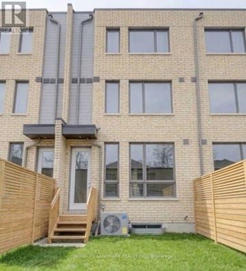 Toronto (Englemount-Lawrence) townhouse for rent - A building with a brown fence in front of it.