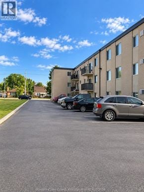 Windsor apartment for rent - A parking lot with cars and a building in the background.