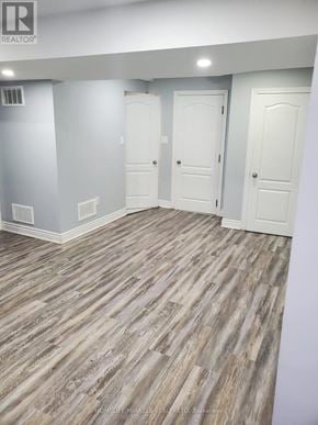 Brampton (Bram East) apartment for rent - A room with wood flooring and three white doors.