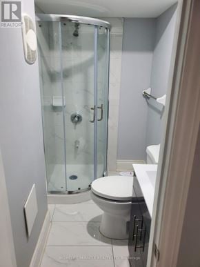 Brampton (Bram East) apartment for rent - A white toilet in a bathroom with a glass shower door.