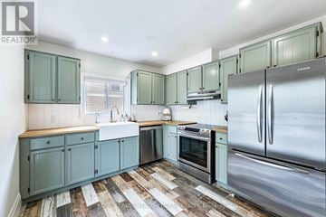 Shelburne apartment for rent - A kitchen with green cabinets and a wooden counter top.