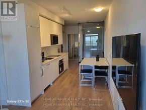Vaughan (Concord) condo for rent - A modern kitchen with white cabinets and a wooden floor.