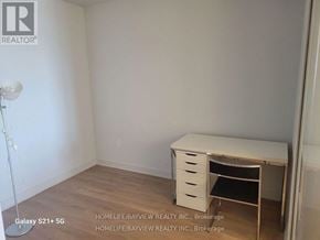 Vaughan (Concord) condo for rent - A white desk with drawers is in a room with a white wall and a floor lamp.