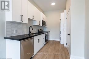Hamilton (Hampton Heights) apartment for rent - A kitchen with white cabinets and a black countertop.