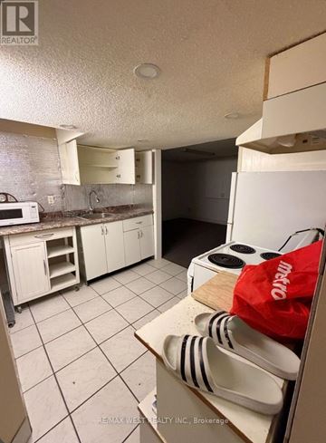 Toronto (Thistletown-Beaumonde Heights) apartment for rent - A kitchen with white cabinets and a white refrigerator.