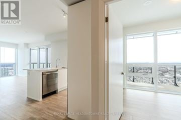 Mississauga (City Centre) condo for rent - A white kitchen with a dishwasher and a refrigerator.