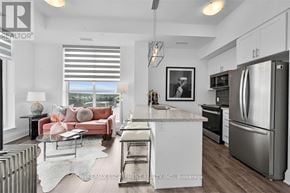 Hamilton (Waterdown) condo for rent - A modern kitchen with stainless steel appliances and a red couch.