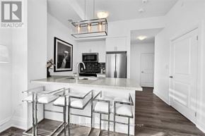 Hamilton (Waterdown) condo for rent - A modern kitchen with white cabinets and a marble countertop.