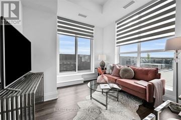 Hamilton (Waterdown) condo for rent - A living room with a red couch and a television.
