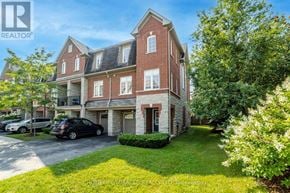 Pickering (Village East) townhouse for rent - A large red brick house with a car parked in front.