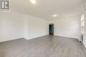Toronto (Oakridge) multi-family for rent - A room with a wooden floor and a door in the middle.