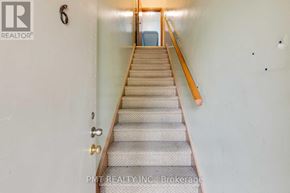 Toronto (Oakridge) multi-family for rent - A staircase with a carpeted runner and wooden handrail.