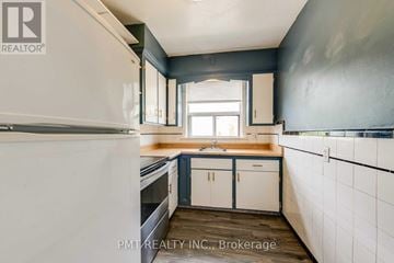 Toronto (Oakridge) multi-family for rent - A kitchen with white cabinets and a white refrigerator.