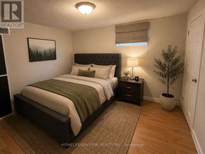 Newmarket (Central Newmarket) apartment for rent - A bedroom with a bed, nightstand, and a plant.