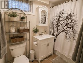 Newmarket (Central Newmarket) apartment for rent - A white bathroom with a toilet, sink, and a tree-like shower curtain.