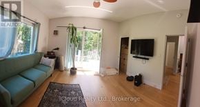 Tiny apartment for rent - A living room with a green couch and a flat screen TV.