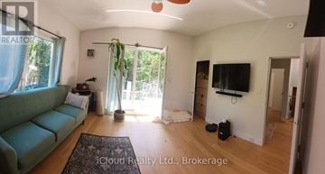 Tiny apartment for rent - A living room with a green couch and a flat screen TV.