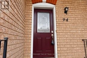 Vaughan (Maple) townhouse for rent - A red door with a glass window and a black handle is on a brick wall.
