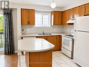 Vaughan (Maple) townhouse for rent - A kitchen with wooden cabinets and white appliances.