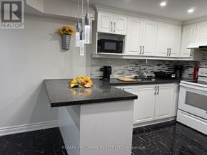 Vaughan (Maple) apartment for rent - A kitchen with a black granite countertop and white cabinets.