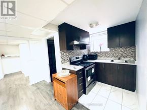 Brampton (Southgate) apartment for rent - A kitchen with black cabinets and a wooden island.