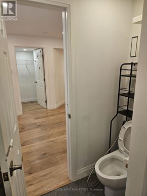 Kitchener apartment for rent - A white toilet in a small bathroom with a wooden floor.