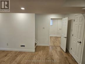 Kitchener apartment for rent - A room with wooden flooring and white walls, with a door on the right.