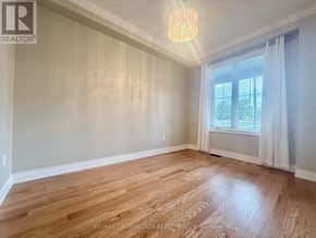 Newmarket (Woodland Hill) townhouse for rent - A room with wooden flooring and a window with white curtains.
