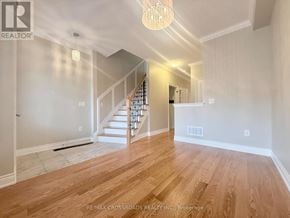 Newmarket (Woodland Hill) townhouse for rent - A spacious room with wooden flooring and a staircase leading to the upper level.
