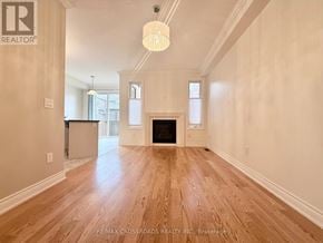 Newmarket (Woodland Hill) townhouse for rent - A spacious room with a fireplace and wooden flooring.