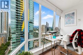 Vancouver apartment for rent - A room with a desk and a chair with a window showing a view of a city.