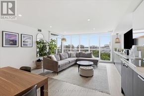 Toronto (Waterfront Communities) condo for rent - A modern living room with a large window overlooking the city.