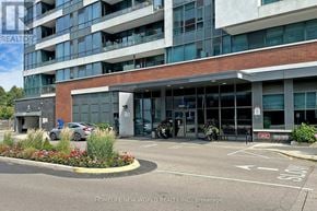 Mississauga (Port Credit) condo for rent - A building with a parking lot in front of it.