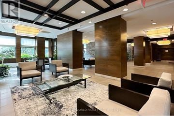 Mississauga (Port Credit) condo for rent - A modern living room with a glass table and a mix of dark and light furniture.