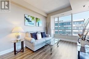 Mississauga (Port Credit) condo for rent - A living room with a white couch and a lamp on a side table.