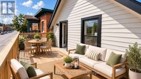 Ottawa triplex for rent - A white house with a wooden deck and patio furniture.