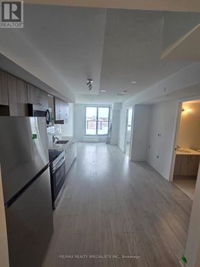 Toronto (Yorkdale-Glen Park) condo for rent - A spacious kitchen with a refrigerator, oven, and a window.