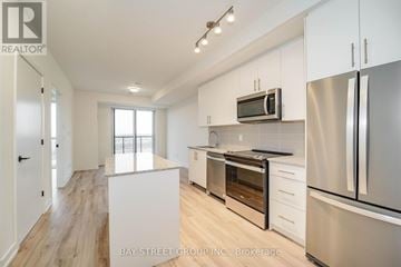 Oakville (Jm Joshua Meadows) condo for rent - A modern kitchen with white cabinets and stainless steel appliances.