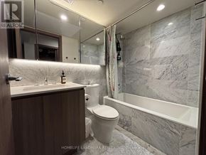 Toronto (Waterfront Communities) condo for rent - A bathroom with a marble wall and a bathtub.