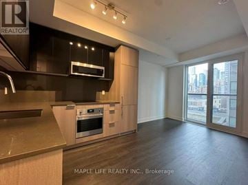 Toronto (Church-Yonge Corridor) condo for rent - A modern kitchen with wooden floors and a large window.